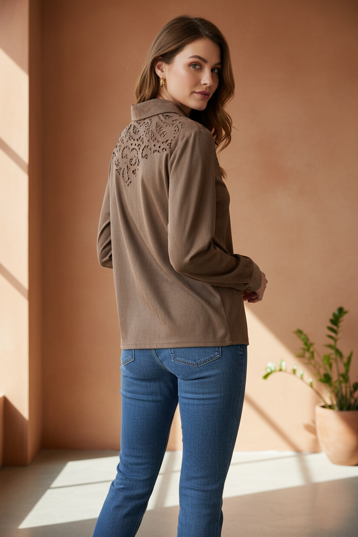 Model wearing a warm taupe button-front top showing the decorative cutout back yoke in a back three-quarter pose.