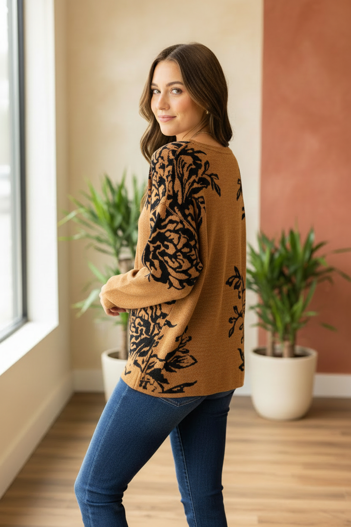 Model wearing a rust-colored Fransa top with black botanical print across the back and sleeves in a back three-quarter pose.