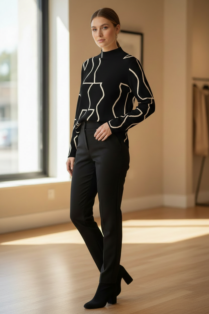 Model wearing a black long-sleeve top with cream abstract geometric line pattern in a three-quarter pose.
